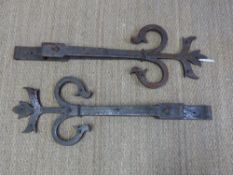 A pair of 18thC fleur de lys wrought iron door hinges,