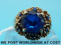 A yellow metal ring marked 14k set with a round cut blue stone,