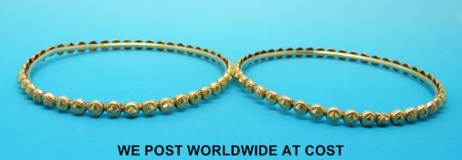 A pair of Indian yellow metal bangles marked 20ct (24.