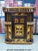 An early 20thC apprentice small parquetry hanging corner cupboard.