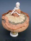 A pin cushion doll with ceramic legs and head