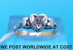 A yellow metal ring marked 18ct set with a diamond in a platinum heart shaped setting (size M)