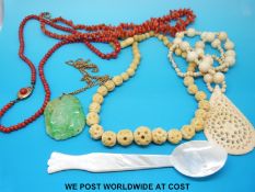 A 9ct gold chain, carved jadeite pendant, two coral necklaces, bone necklace,