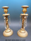 A pair of 19thC gilt metal candlesticks with caryatid figures and glass lustre drops,