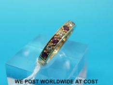 A yellow metal half eternity ring set with alternating diamonds and rubies (size J)