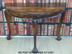 A 19thC circular fold over table with ball and claw feet, possibly camphor or rosewood (width 117cm,