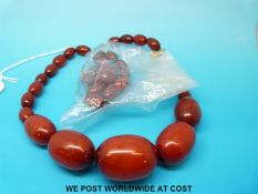 A graduated amber necklace consisting of red amber beads, 65g.