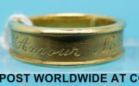 An 18ct gold ring with French writing around the band by Laura Lee, 6.
