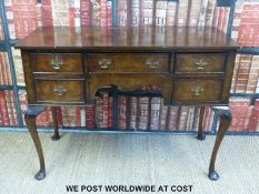 A c1920s walnut knee hole desk with cabriole legs and brass drop handles.