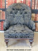 A 19thC mahogany upholstered armchair with carved legs and raised on ceramic castors