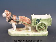 A Royal Dux figure of a dog pulling a cart,