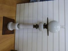 An opaline glass oil lamp with brass mounts, on oak base,