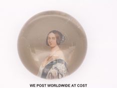 A pair of reverse painted glass paperweights with portraits of Queen Victoria and Prince Albert,