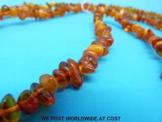 An amber necklace consisting of irregular opaque, translucent and transparent beads (152cm long,