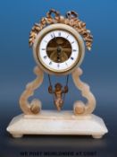 An alabaster novelty clock with visible movement, the pendulum in the form of a cherub on a swing,