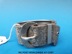 A white metal bracelet in the form of a buckle with chased decoration (54.