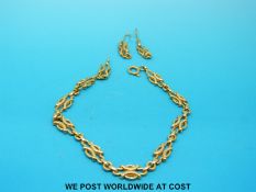 A pair of yellow metal earrings and a matching bracelet (16.