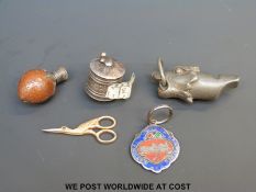 A nut made into a scent bottle, a white metal cased tape measure,