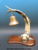 An Edwardian dinner bell inthe form of a dolphin made up of horn with silver plated mounts,