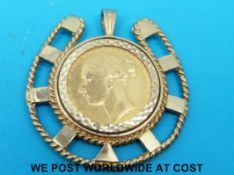 A yellow metal horseshoe shaped pendant set with an 1879 gold full sovereign (14.