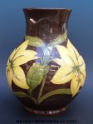 A large Moorcroft vase in Lily pattern on a brown ground (10