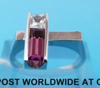 A white metal ring marked 14k set with pink topaz and a white sapphire (size O)