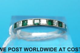 A platinum ring set with alternating square step cut emeralds and diamond (size P)