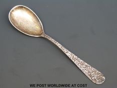 A white metal spoon marked Sterling Stieff with floral handle in relief,