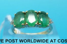 A 9ct gold ring set with three oval cut emeralds (size K)