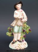 A 19thC Staffordshire figure of a gentleman with bocage decoration (20cm tall)