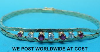 A 9ct gold bracelet set with alternating diamonds and rubies