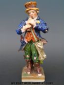 A Sitzendorf ragged street urchin figure (17cm tall)
