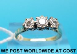 An 18ct gold ring set with three diamonds in an illusion setting (size M)