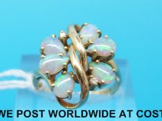 A 14ct gold ring set with six opals and two diamonds