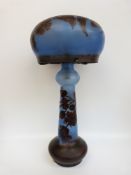 An overlaid cameo glass table lamp with red floral decoration over blue ground,