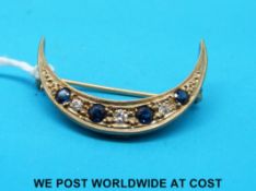 A 9ct gold crescent brooch set with alternating sapphires and diamonds