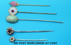 Five yellow metal stick pins,