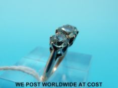 A yellow metal ring set with three round cut blue zircons (size K)