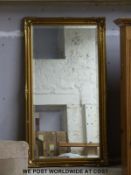 A gilt bevelled edge framed mirror (approximately 75cm x 135cm overall)