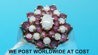 A 9ct gold ring set with opals and rubies in a cluster (size P)