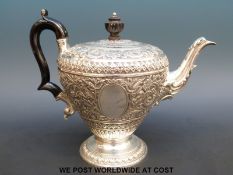A William IV or Victorian hallmarked silver teapot with embossed decoration, height 18cm,