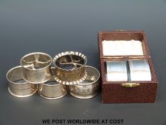 Four hallmarked silver napkin rings (34g) together with further plated examples
