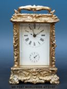 A decorated brass carriage alarm clock with half hour repeater mechanism and alarm striking on a