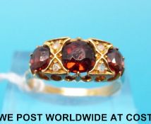 An 18ct gold ring set with garnet and diamonds (size P)