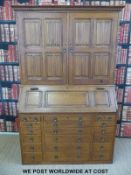 An oak bureau bookcase with carved linen fold decoration by South West Joinery, Gloucester.