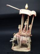 A carved bone chess piece or similar formed as an elephant with passengers under cover (height