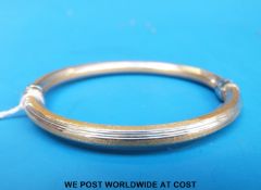 A bi-coloured bangle marked 750 (10.