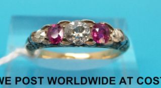 An Edwardian ring set with alternating diamonds and rubies in scrolling setting marked 18ct gold