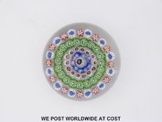 Baccarat concentric millefiori glass paperweight with a central white cane surrounded by a band of