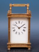 A gilt-cased late 19thC / early 20thC carriage clock with white enamel dial and pierced panels